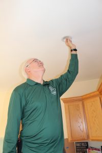 HWE installing an LED lightbulb during a home energy assessment